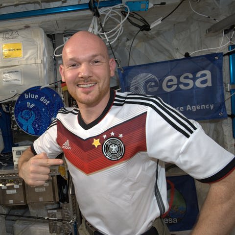 Alexander Gerst im Juli 2014 mit einem T-Shirt der deutschen Fußballnationamannschaft – ergänzt um einen 4. Stern nach der gewonnenen Weltmeisterschaft 
