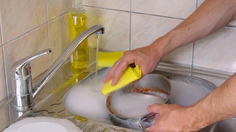 Der Spüllappen muss sauber sein und sollte täglich gewechselt werden. Es reicht, ihn bei 60°C mit Vollwaschmittel zu waschen. Eine Wäsche bei 95°C bringt keinen höheren Effekt bei der Reduktion von Bakterien. 