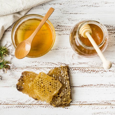 Honiggläser und Wabe: Krebspatienten sollten möglichst wenig Industriezucker zu sich nehmen und bei Süßhunger lieber zu Marmelade oder Honig greifen. 