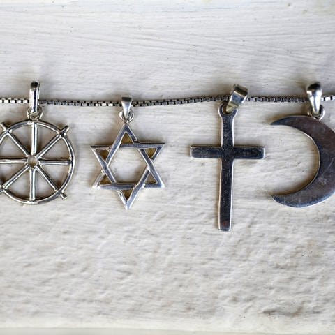 Religioöse Symbole repräsentieren verschiedene Glaubensrichtungen wie Islam, Christentum und Judentum (Foto: IMAGO, IMAGO / Leemage)