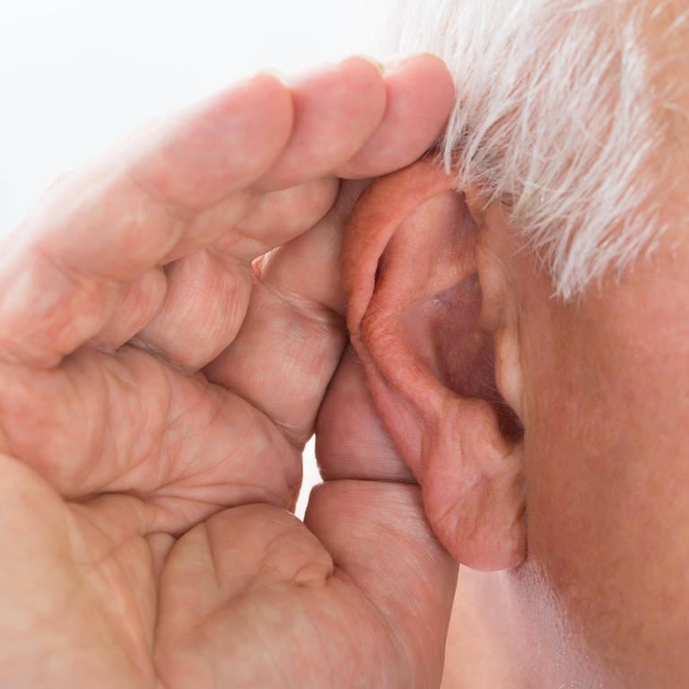 Älterer Mann hält sich die Hand hinters Ohr, um besser zu hören: Das Gehör von Dementen zu testen ist nicht ganz einfach. Es gibt heute jedoch Verfahren, die man bei betagten und dementen Personen verwenden kann – objektive Tests, bei denen man keine weitere Mitarbeit der Patientinnen und Patienten braucht.