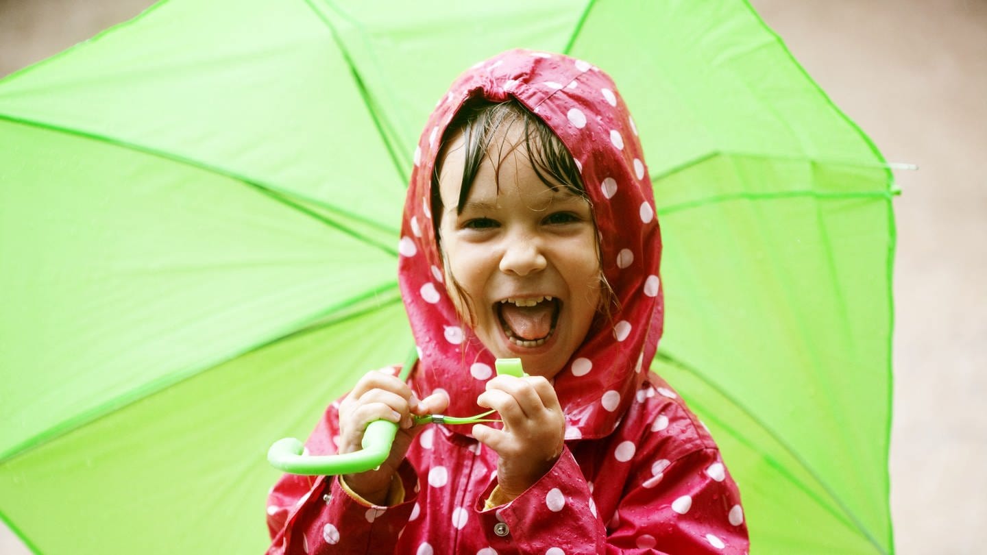 Lachendes Kind im roten Regenmantel mit grünem Schirm: Seriöse Wettervorhersagen sind maximal für 5 is 7 Tage möglich. Eine gewisse Toleranz muss immer einkalkultiert werden (Foto: Colourbox)