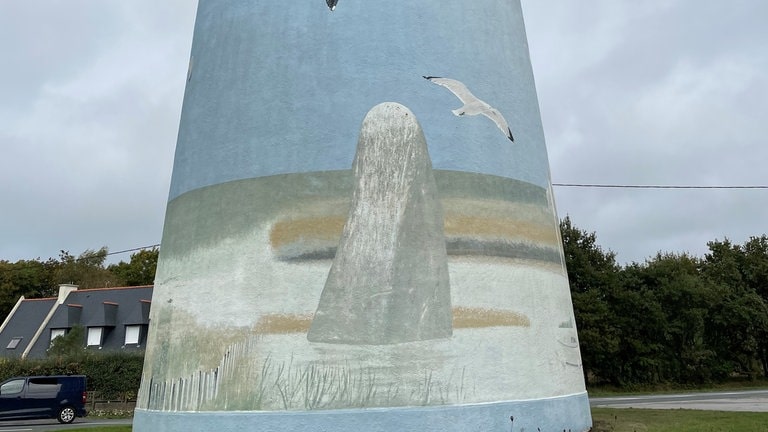 Auf der anderen Seite des Wasserturms von Treffiagat ist der Menhir de Léhan zu sehen, der sich ebenfalls in der Gemeinde Treffiagat befindet.