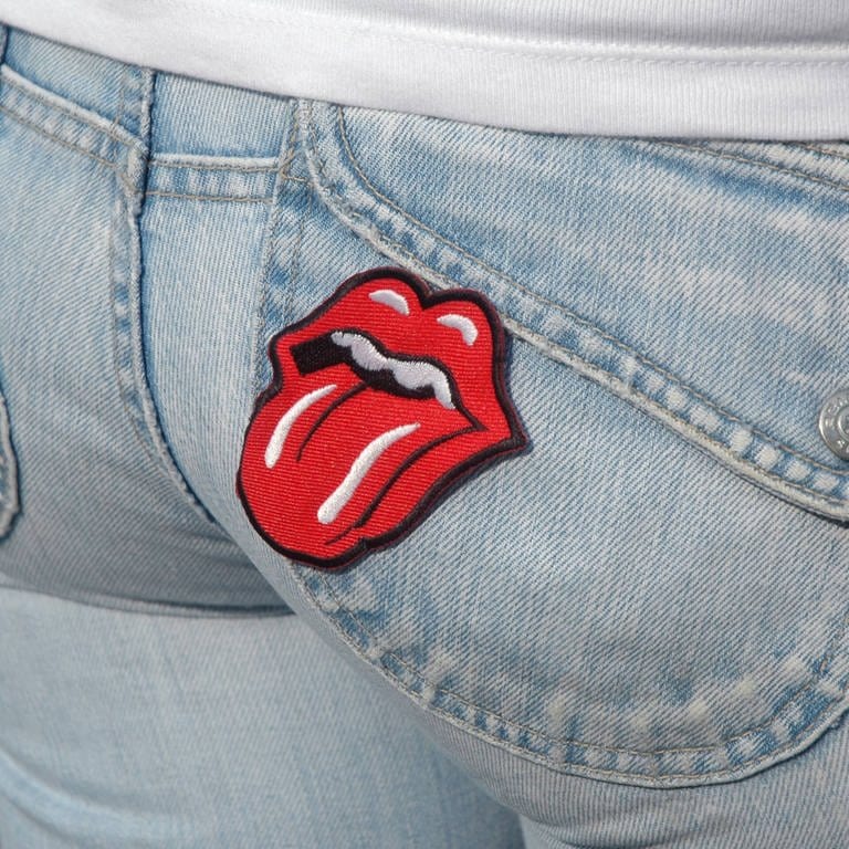 Stones-Zunge auf der Jeans einer Frau