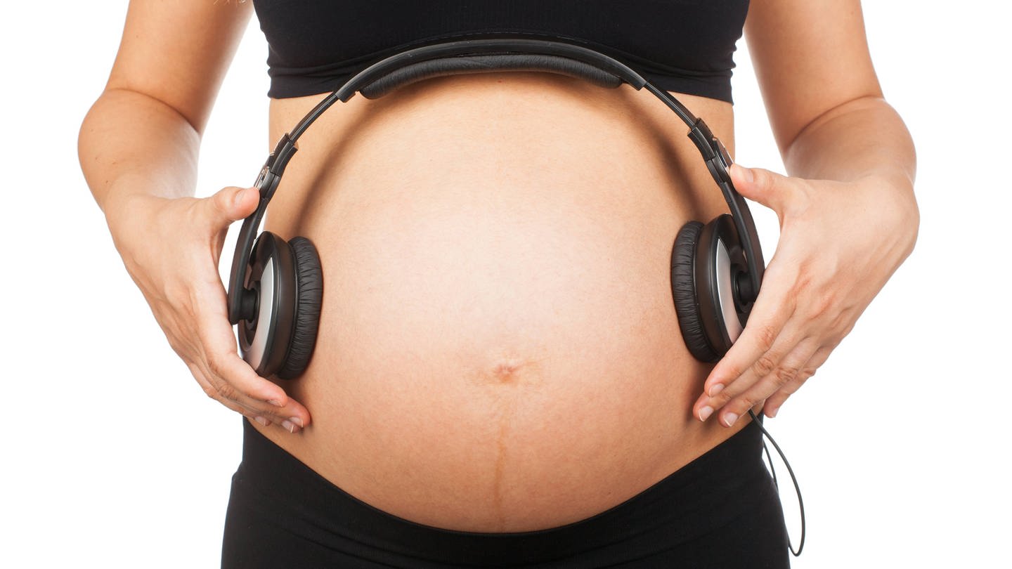 Kopfhörer auf dem Bauch einer Schwangeren (Foto: IMAGO, imago images / CHROMORANGE)