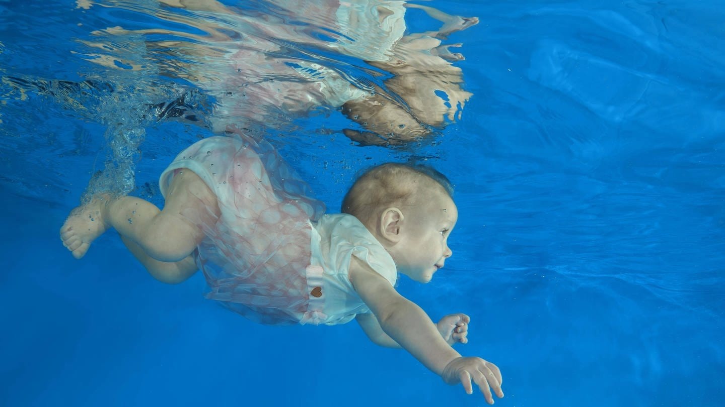 Säugling taucht in Schwimmbecken (Foto: IMAGO, imago images / imagebroker)