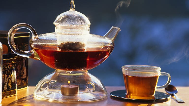Schwarzer Tee: Teekanne, Stövchen und Teetasse