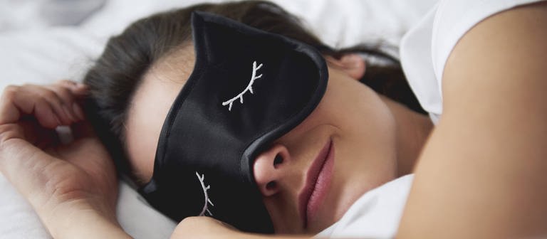 Junge Frau im Bett mit Schlafmaske  (Foto: imago images, imago 0087049199)