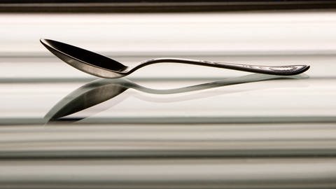 Ein Silberlöffel reflektiert in einem Spiegel (Foto: IMAGO, Dmitry Pistrov 2007 via www.imago-images.de)