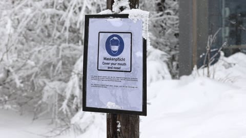 Schild im Schnee mit der Aufschrift Maskenpflicht (Foto: imago images, imago images / Susanne Hübner)