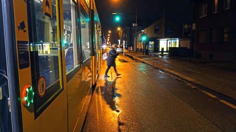 Frau steigt im Dunkeln aus Straßenbahn (Foto: IMAGO, imago images / Gottfried Czepluch)