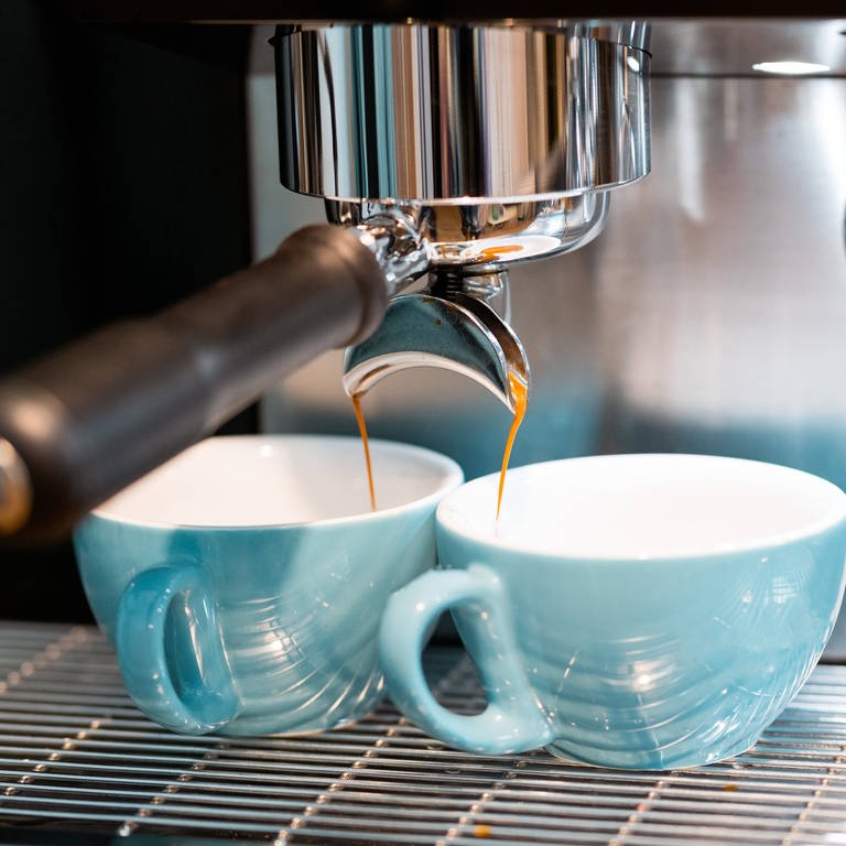 Zwei blaue Tassen unter Espressomaschine: Warum schmeckt Espresso anders als Filterkaffee? (Foto: IMAGO, IMAGO / Addictive Stock)