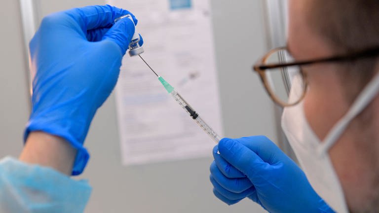 Person zieht Injektionsspritze auf (Foto: IMAGO, IMAGO / MiS)