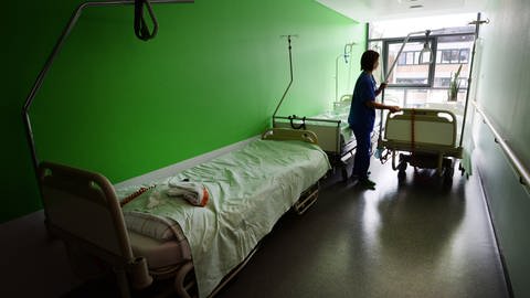 Eine Krankenschwester steht im Krankenhausgang und holt ein Bett ab (Foto: picture-alliance / Reportdienste, Picture Alliance)