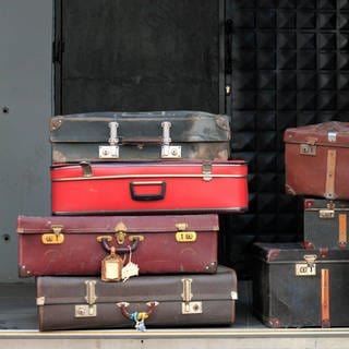 Sieben alte Koffer: Warum packt man seine "Siebensachen" zusammen? Warum nicht sechs oder acht? (Foto: imago images, IMAGO / H. Tschanz-Hofmann)