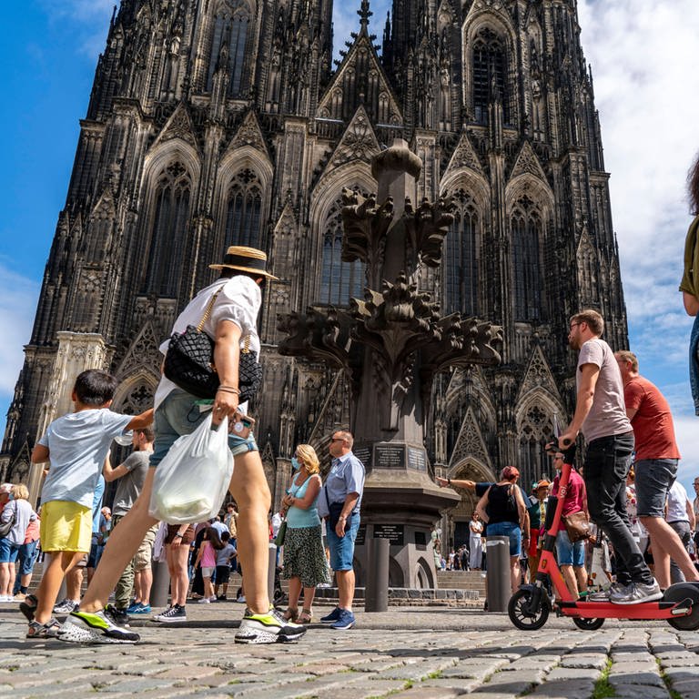 Menschen auf der Kölner Domplatte: Stimmt es, dass der Kölner Dom sich selbst gehört? (Foto: IMAGO, IMAGO / Jochen Tack)