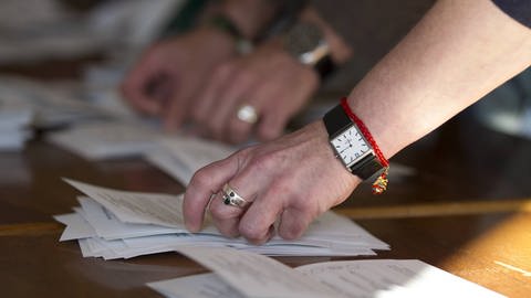 Hände, die Zettel auszählen: 600.000 bis 700.000 Menschen helfen als ehrenamtliche Freiwillige bei einer Bundestagswahl in Deutschland (Foto: imago images, IMAGO / Eibner)