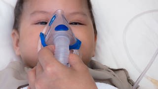 Baby mit RSV hängt an Sauerstoffmaske. (Foto: imago images, IMAGO / agefotostock)