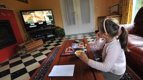 Ein Mädchen schaut eine Comicserie im Fernsehen. (Foto: IMAGO, IMAGO / Xinhua)