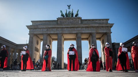 Demonstrantinnen mit "Handmaid's Tale"-Kostümen und Schildern mit der Aufschrift "Ni una menos  Nicht Eine mehr" machen im Rahmen der Frauentagsdemo 2021 in Berlin auf Femizide aufmerksam (Foto: IMAGO, IMAGO / Bildgehege)
