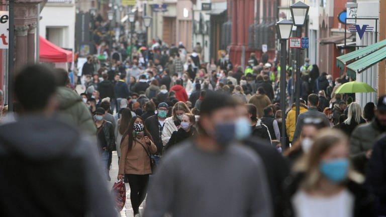 Einkaufsstraße voller Menschen mit Maske (Foto: IMAGO, IMAGO / Ralph Peters)