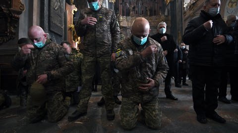Soldaten und Einwohner beten während der russischen Invasion in die Ukraine. (Foto: picture-alliance / Reportdienste, picture alliance/dpa/ZUMA Press Wire)