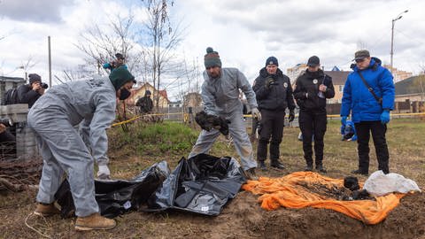 Forensische Polizisten exhumieren Leichen in Butcha, am Stadtrand von Kiew. (Foto: IMAGO, IMAGO/Mykhaylo Palinchak)