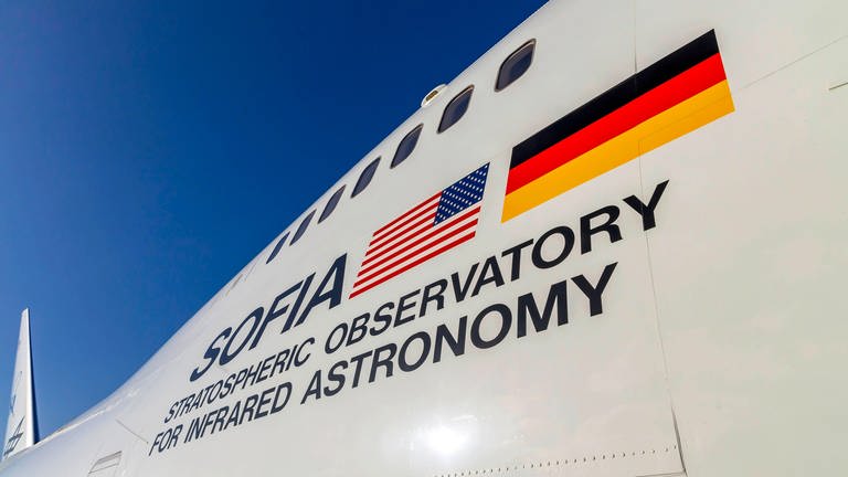 Aufschrift "SOFIA - Stratospheric Observatory for Infrared Astronomy" mit US-amerikanischer und deutscher Flagge auf der Boing 747, in der sich das Teleskop befindet. (Foto: IMAGO, IMAGO / Arnulf Hettrich)