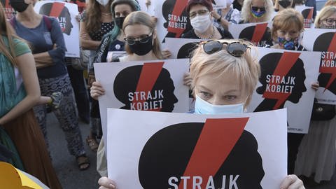 Demonstrantinen mit Mundschutz halten im Juli 2020 Schilder mit der Aufschrift «Frauen Streik» hoch. Der Protest richtet sich gegen die Pläne der Regierung von Polen, sich aus der Istanbul-Konvention zurückzuziehen (Foto: dpa Bildfunk, Czarek Sokolowski)