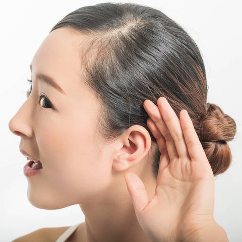 Junge Person hält sich die Hand hinter das Ohr, um genau hinzuhören (Foto: IMAGO, imago images/Imaginechina-Tuchong)