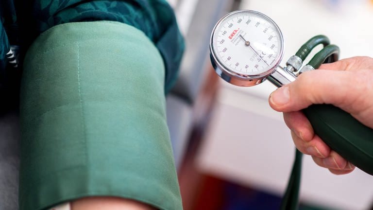 Ein Arzt misst den Blutdruck einer Patientin (Symbolbild). (Foto: dpa Bildfunk, picture alliance/dpa | Hauke-Christian Dittrich (Symbolbild))