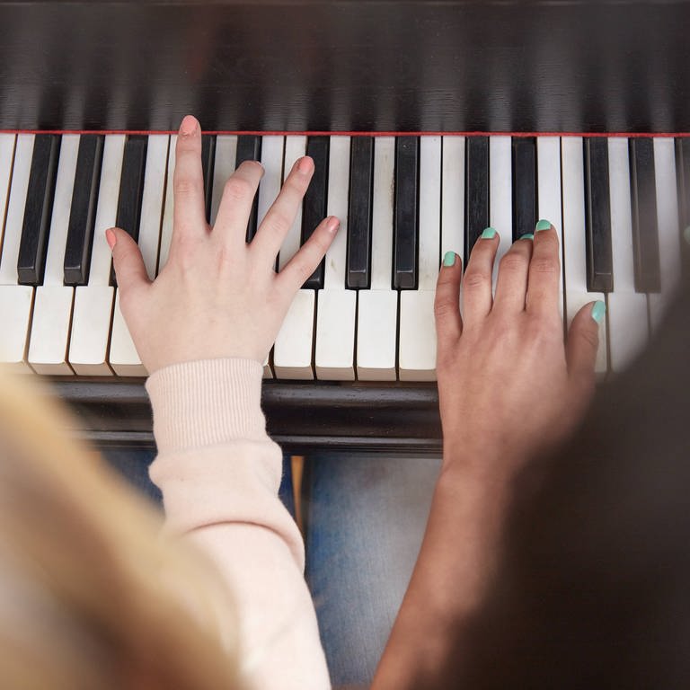 Zwei Menschen spielen an einer Klaviertastatur (Foto: IMAGO, imago/Westend61)
