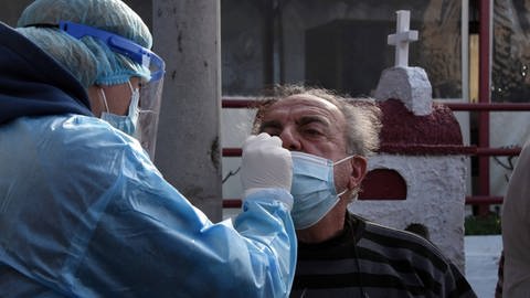 Ein älterer Herr wird von einem medizinischen Mitarbeiter durch die Nase auf Corona getestet. (Foto: IMAGO, imago images/ANE Edition)