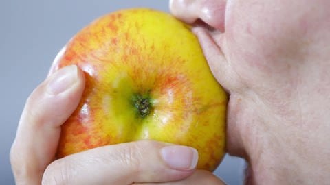 Nahaufnahme von Mund mit Apfel (Foto: IMAGO, Thomas Trutschel/photothek via www.imago-images.de)