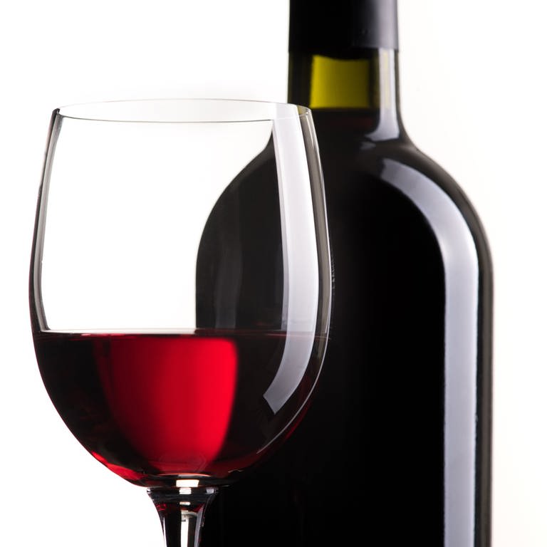 Rotweinglas und Flasche vor weißem Hintergrund (Foto: IMAGO, stokkete via www.imago-images.de)