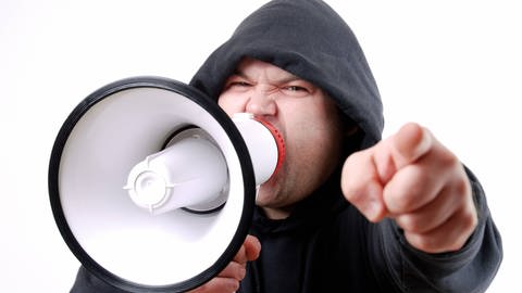 Mann mit Megafon schreit seine Wut heraus (Foto: IMAGO, IMAGO / mm images/Neudert)