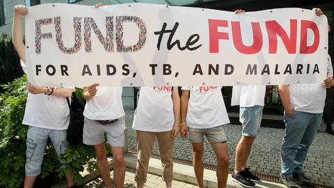 Plakat einer Demonstration 2016 vor der deutschen Botschaft in Kiew mit der Forderung, die Finanzierung des Global Fonds zur Bekämpfung von AIDS, Tuberkulose und Malaria nicht zu kürzen (Foto: IMAGO, IMAGO / Ukrainian News)