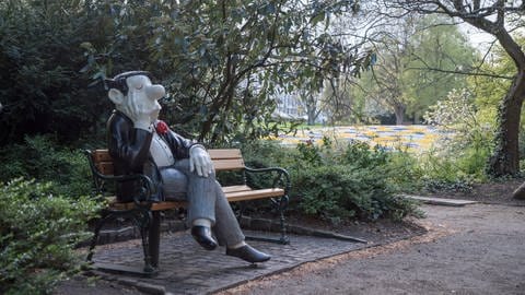 Lebensgroße Loriot-Figur sitzt auf Parkbank in den Wallanlagen am Loriotplatz in Bremen (Foto: picture-alliance / Reportdienste, picture alliance / Robert B. Fishman, ecomedia | Robert B. Fishman)