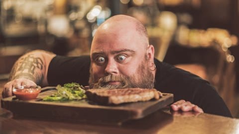Mann starrt gebannt auf ein Steak (Foto: IMAGO, Image / agefotostock)