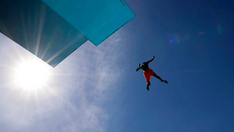 Mann springt von einem Schwimmbad-Sprungturm (Foto: IMAGO, IMAGO / Future Image)