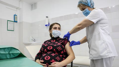 Eine schwangere Frau lässt sich gegen Covid impfen. (Foto: IMAGO, IMAGO / ITAR-TASS)