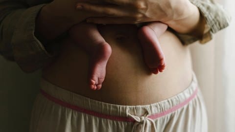 Eine Frau hält ihr Neugeborenes an ihre Brust. (Foto: IMAGO, IMAGO / Westend61)
