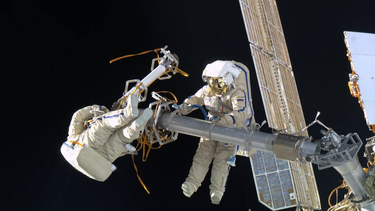 Andre Kuipers fängt seine russischen Besatzungsmitglieder bei einem Weltraumspaziergang außerhalb der Internationalen Raumstation ein. (Foto: Pressestelle, ESA/NASA)