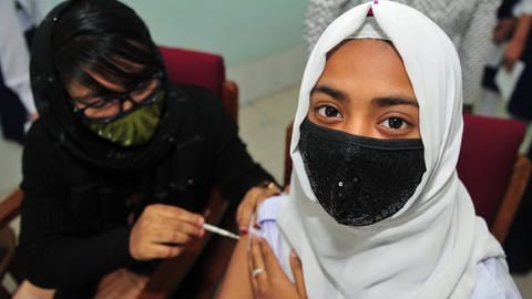 A student from Bangladesh receives the BioNtech Pfizer vaccine.  (Photo: IMAGO, IMAGO / UIG)