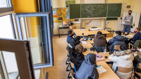 Schulklasse mit Jacken im Klassenzimmer (Foto: IMAGO, IMAGO / Reichwein)