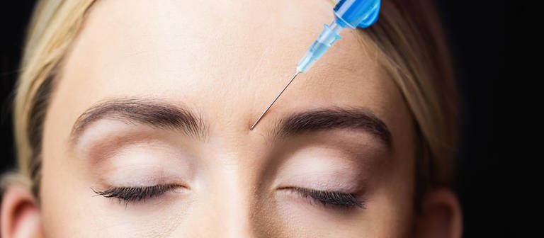Frau erhält Botox-Spritze in die Stirn. (Foto: IMAGO, IMAGO / YAY Images)