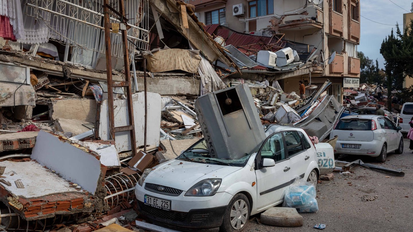 Das Bild zeigt die Folgen des Erdbebens in der Grenzregion Türkei/Syrien: Zerstörte Gebäude, Autos und Straßen. (Foto: IMAGO, ZUMA Wire)