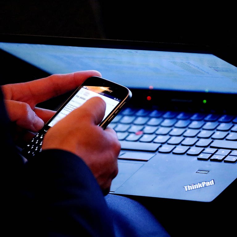 Person sitzt am Laptop und am Smartphone gleichzeitig (Foto: picture-alliance / Reportdienste, / dpa)