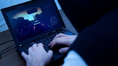 Ein Mann spielt auf seinem Laptop ein Computerspiel. (Foto: picture-alliance / Reportdienste,  / dpa Themendienst)