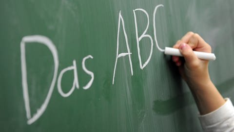 Schülerin schreibt das ABC an die Tafel. (Foto: picture-alliance / Reportdienste, picture alliance / dpa | Daniel Reinhardt)